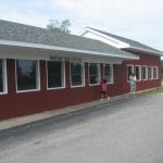 Family standing infront of Manistique hook ladder 1883